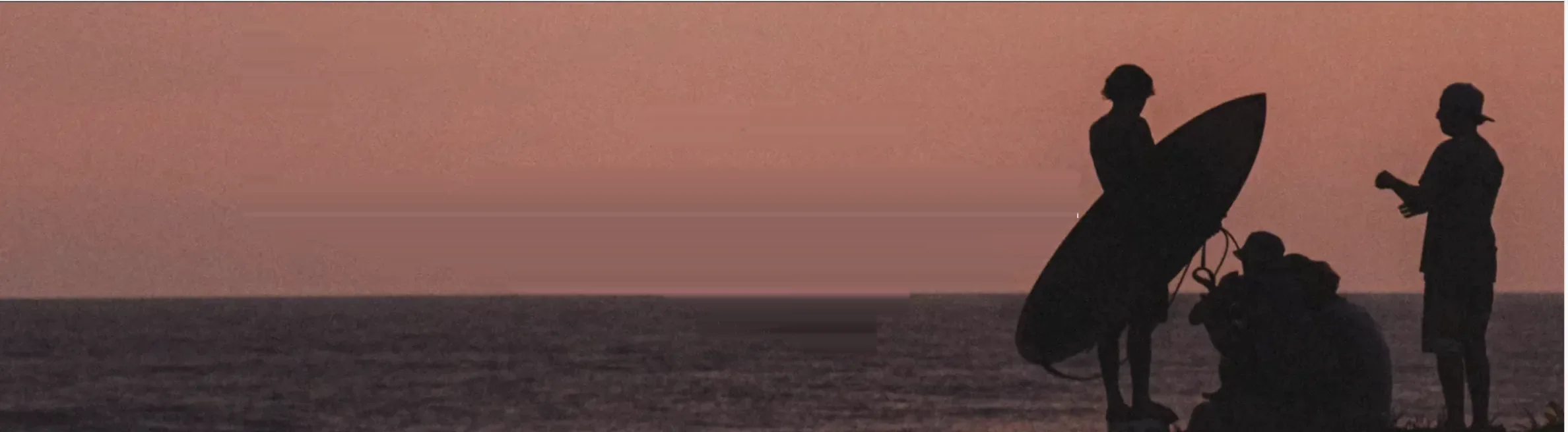 Atardecer en la playa de El Paredón, siluetas de surfistas